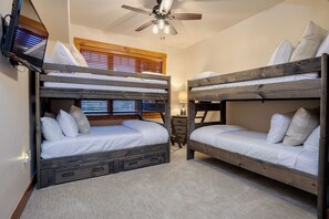 A bunk bed room with wooden frames, a ceiling fan, and a window with blinds. - EL5209 | Gorgeous Second Floor Residence | Very Spacious | Air Chilling | Pool (Steamboat Springs)