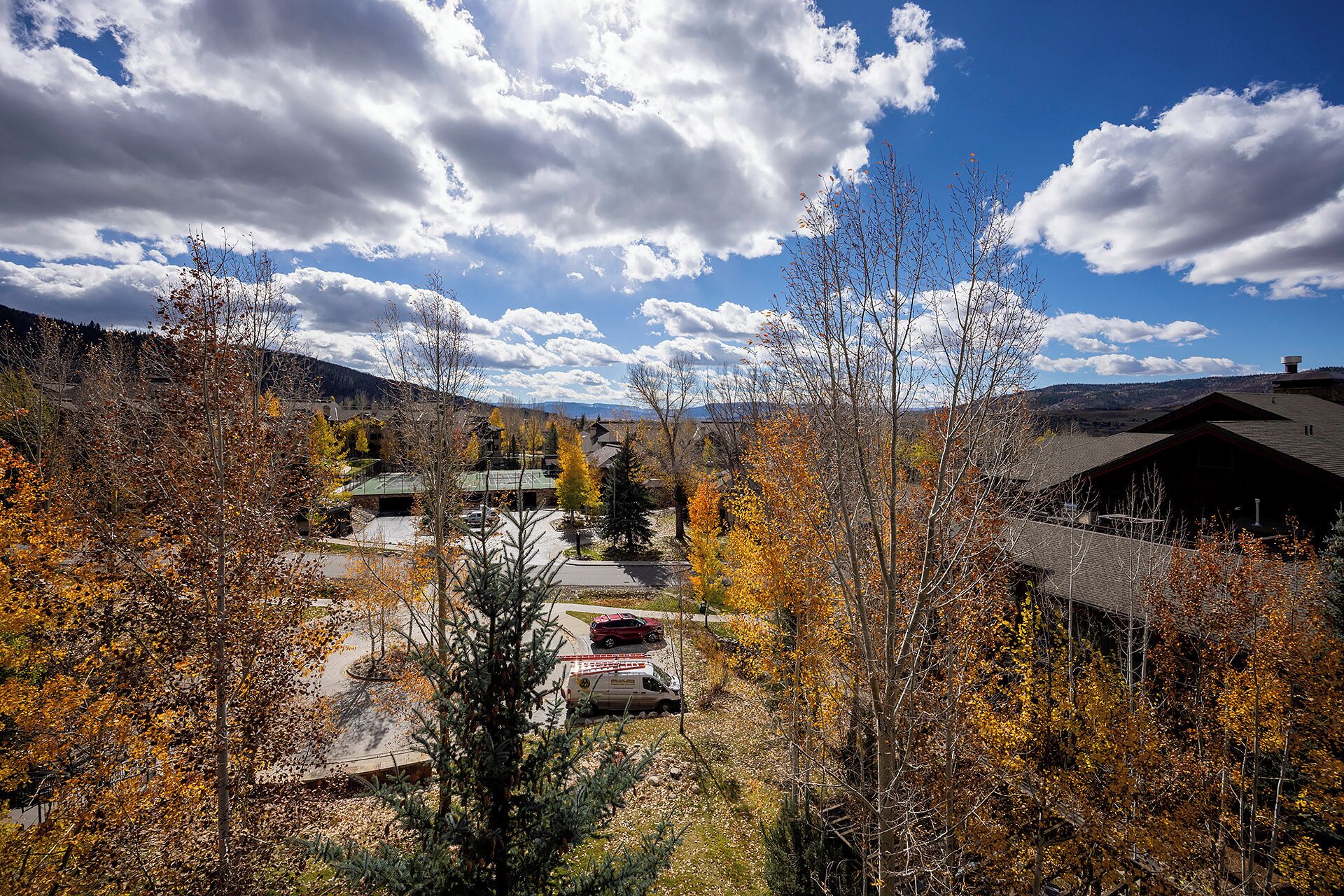 A residential area with houses, a parking lot, and a mountain backdrop.