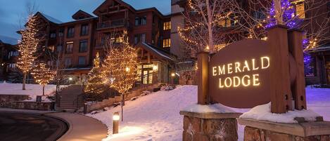 A snow-covered landscape with a sign for Emerald Lodge.