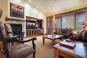 A cozy living room with a fireplace, a television, and a comfortable seating area. - EL5305 | Top Floor with Mountain Views | Air Chilling | 10 Hot Tubs | 4 Pools (Steamboat Springs)
