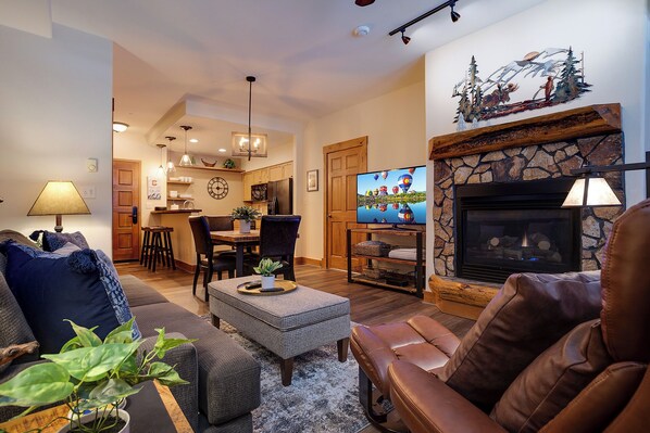 A cozy living room with a fireplace, a dining area, and a kitchen. - TL2109 | Perfect for a Couple or Small Family | A/C | Great Amenities (Steamboat Springs)