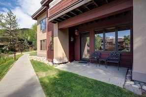 A building with a covered porch, stone pathway, and outdoor seating. - TL2110 | Perfect Getaway | Winter Shuttle | 10 Hot Tubs | Private Patio (Steamboat Springs)