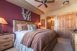 A bedroom with a bed, bedside tables, a ceiling fan, and a wardrobe. - TL2210 | Perfect for a Couple | Winter Specials | Winter Shuttle | 10 Hot Tubs (Steamboat Springs)