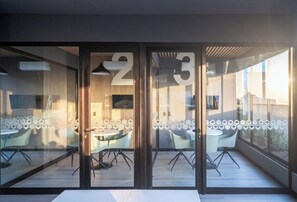Ein moderner Büroraum mit Glastrennvorrichtungen, nummerierten Türen und Blick nach außen.