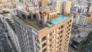 Ein Hochhaus mit Pool auf dem Dach und einer Terrasse.