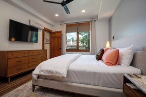 A bedroom with a bed, a TV, a ceiling fan, a window, and a wooden dresser. - TL2211 | Mountain Condo | Close to Skiing | A/C | 10 Hot Tubs (Steamboat Springs)