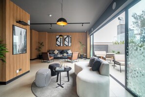 Een moderne woonkamer met een bank, stoelen, een salontafel en een eethoek met een tafel en stoelen.