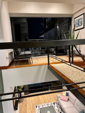 A modern interior with a staircase, a sofa, and a dining area. - Modern Duplex with Terrace | Alcanfores (Miraflores)