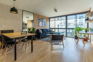 A modern living room with a dining area, large windows, and a view of the city. - Boutique Loft | Miraflores Center | A/C (Miraflores)