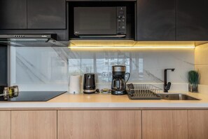 A modern kitchen with a built-in microwave, coffee maker, and a stainless steel sink. - Boutique Loft | Miraflores Center | A/C (Miraflores)