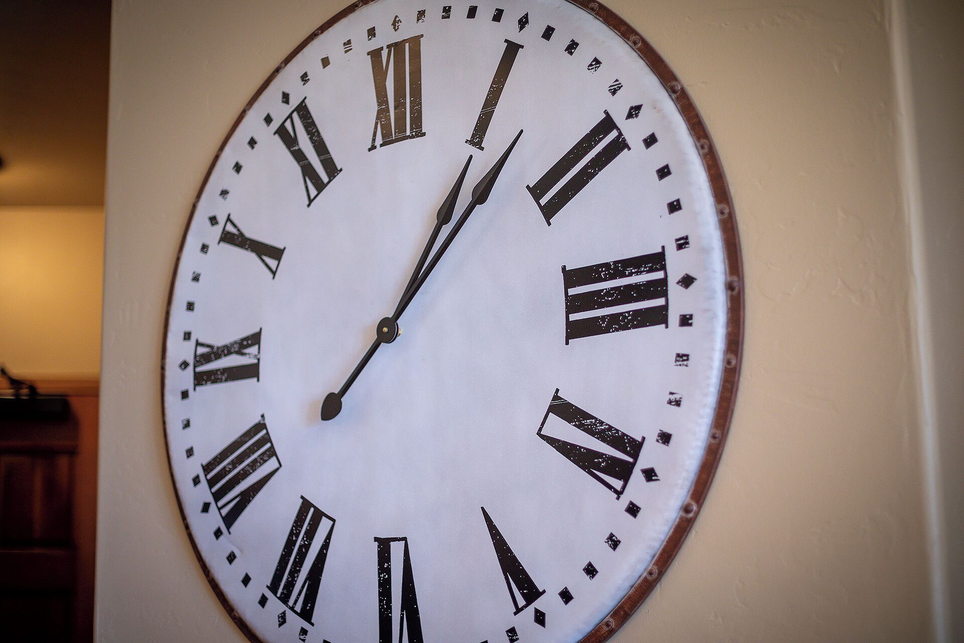 Eine Wanduhr mit römischen Ziffern und schlichtem Design.
