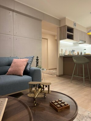 A modern living room with a sofa, a coffee table, and a small airplane model. - Boutique 2BR in Miraflores | Pool · Gym · BBQ (Miraflores)