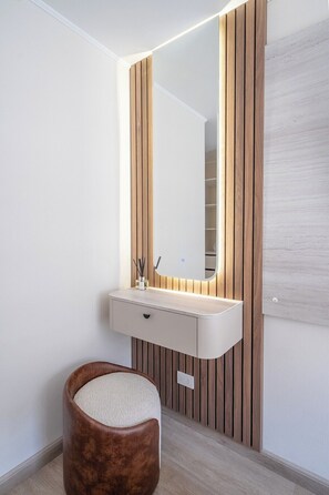A modern bathroom with a vanity, mirror, and wooden panel wall. - Miraflores 3BR | Rooftop · Oficina · Smart TV (Miraflores)