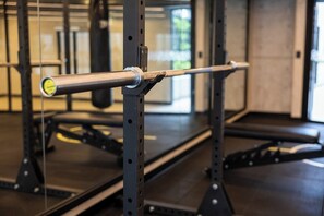 Eine Langhantel auf einem Gewichtsständer in einem Fitnessstudio.