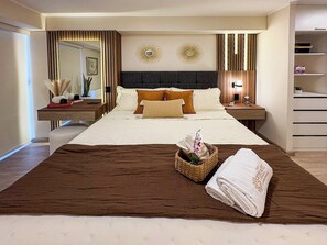 Une chambre d’hôtel avec un grand lit, une table de chevet, un miroir et une étagère fixée au mur.