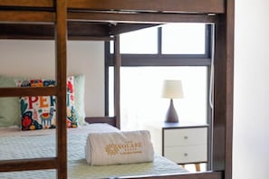 Ein Bett mit einem Kissen mit bunten Mustern und einem Handtuch mit Text.