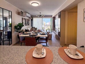 Une cuisine moderne avec un coin repas, de grandes fenêtres et une vue sur la ville.