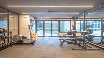 A gym with weightlifting equipment, treadmills, and dumbbells.
