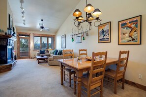 A dining area with a wooden table and chairs, a chandelier, and a fireplace. - TL2303 | Top Floor | Perfect Steamboat Getaway | A/C | 10 Hot Tubs (Steamboat Springs)
