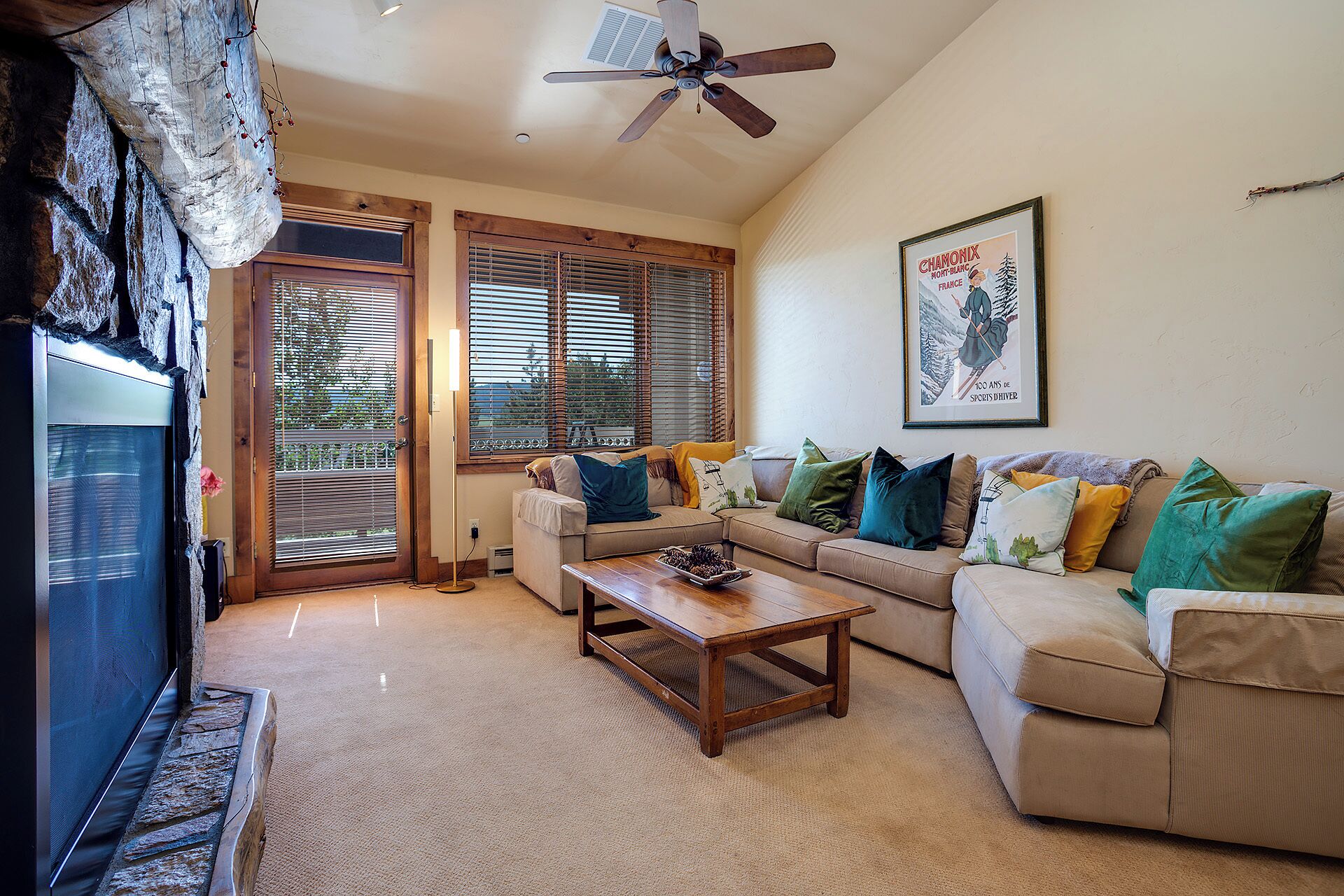 A living room with a sofa, a coffee table, and a ceiling fan.