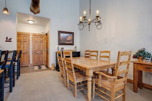 A dining room with a wooden table and chairs, a chandelier, and a painting on the wall. - TL2304 | Beautifully Appointed | Vaulted Ceilings | A/C | 10 Hot Tubs (Steamboat Springs)