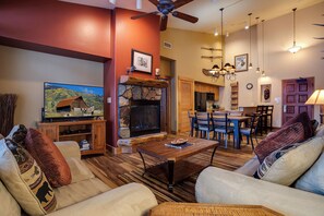 A cozy living room with a fireplace, wooden furniture, and a television. - TL2306 | Top floor | Amenities Galore | Beautiful Residence | A/C (Steamboat Springs)