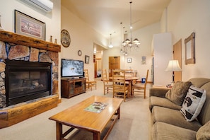 Ein gemütliches Wohnzimmer mit Kamin, Holzmöbeln und einem Fernseher.