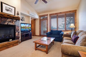 A living room with a fireplace, television, and two sofas. - TL2312 | Lovely Top Floor Condo | Beautiful Views | 10 Hot Tubs | A/C (Steamboat Springs)