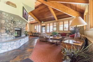 A spacious lobby with a stone fireplace, wooden ceiling beams, and comfortable seating areas. - TR1111 | Perfect for families or group of couples | A/C | 10 Hot Tubs (Steamboat Springs)