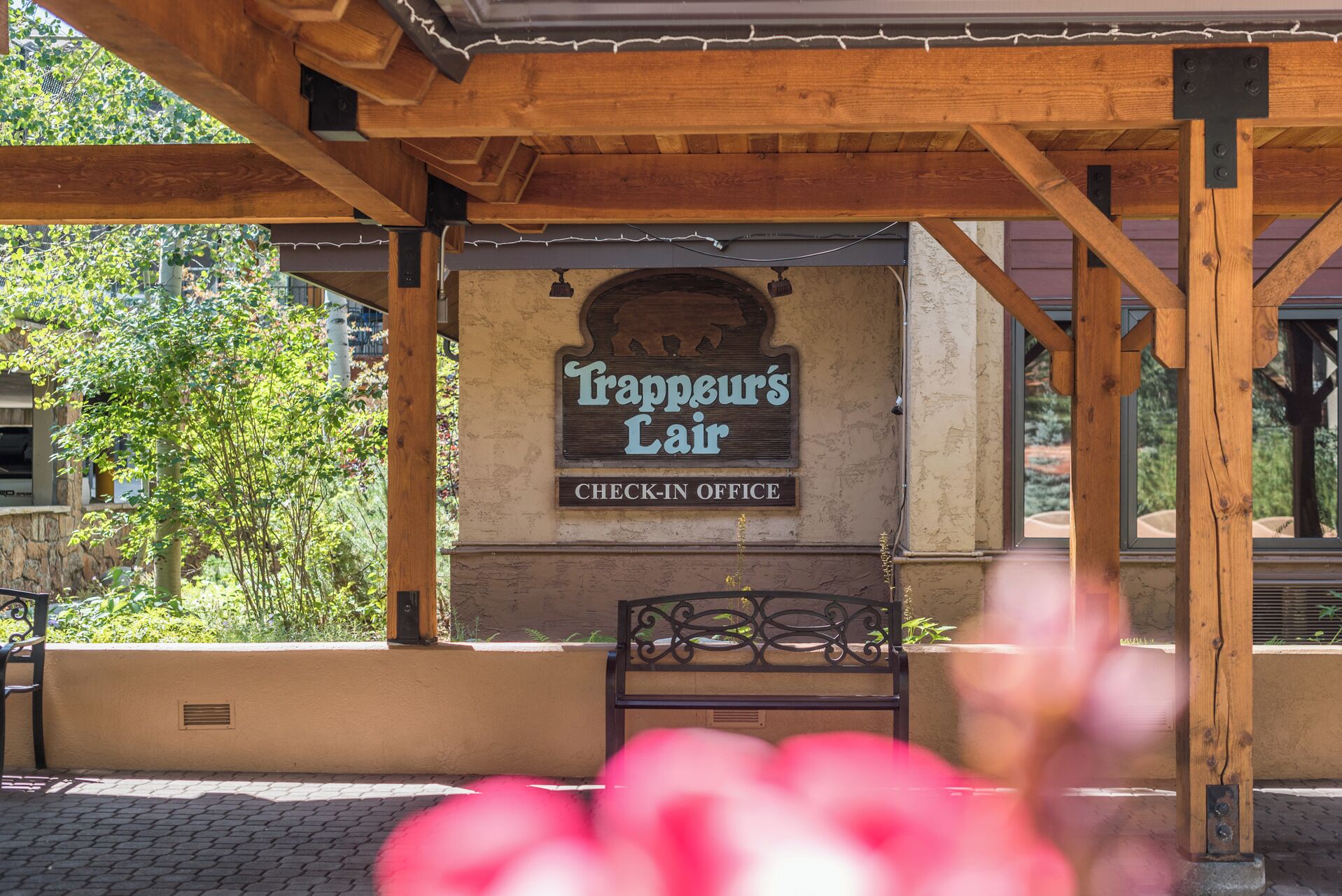 Eine Pergola aus Holz mit einem Schild, auf dem 'Trappeur's Lair Check-in Office' steht.