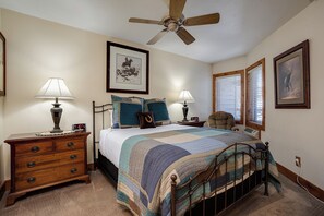A bedroom with a bed, two bedside tables, a nightstand, a ceiling fan, and framed pictures on the walls. - TR1201 | Beautiful Home | Close to Skiing | A/C | 10 Hot Tubs (Steamboat Springs)