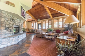 A spacious lobby with a stone fireplace, wooden ceiling beams, and comfortable seating areas. - TR1201 | Beautiful Home | Close to Skiing | A/C | 10 Hot Tubs (Steamboat Springs)