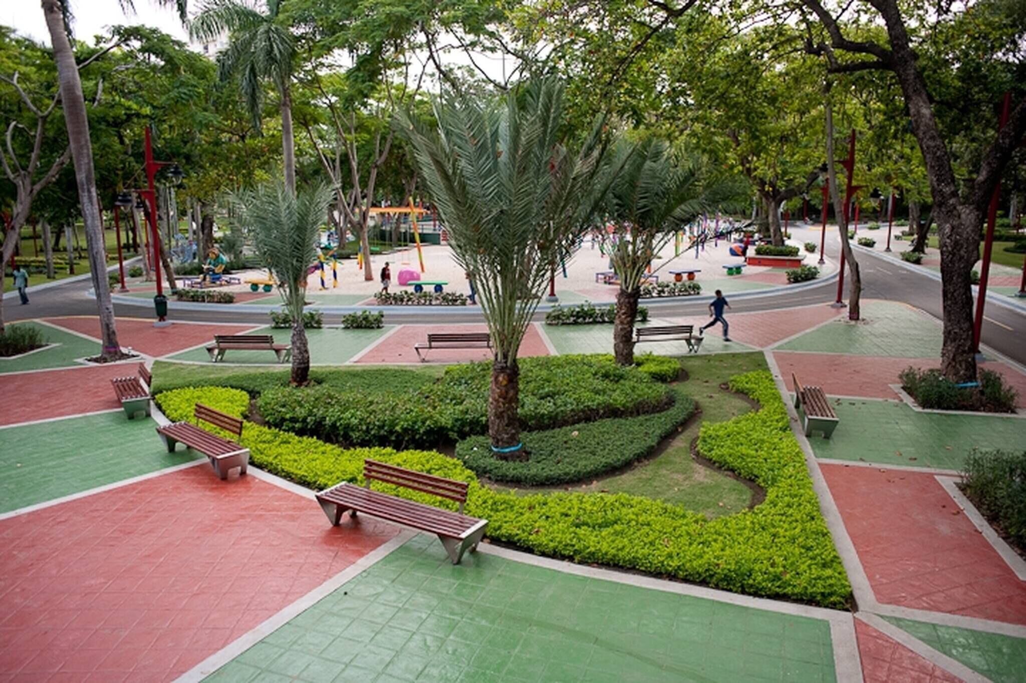 A park with benches, pathways, and trees.