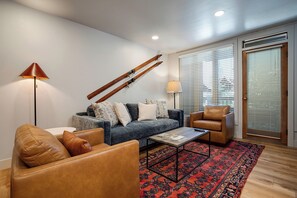 A modern living room with a sofa, two armchairs, a coffee table, a floor lamp, and a patterned rug. - TR1205 | Nicely Furnished Condo | Close to Skiing | A/C | 10 Hot Tubs (Steamboat Springs)