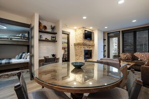 A modern living room with a glass-top dining table, a fireplace, and a cozy seating area. - TR1207 | Close to Skiing | 10 Hot Tubs | Winter Shuttle | 4 Pools (Steamboat Springs)