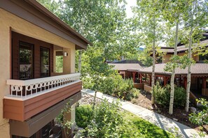 A building with a balcony overlooking a garden with trees and a pathway. - TR1210 | Great Space for a Small Family | A/C | 10 Hot Tubs (Steamboat Springs)