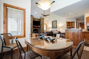 A dining area with a round table, chairs, a fireplace, and a television mounted on the wall. - TR1211 | Phenomenal Mtn Getaway | Close to Skiing | Hot Tubs | A/C (Steamboat Springs)