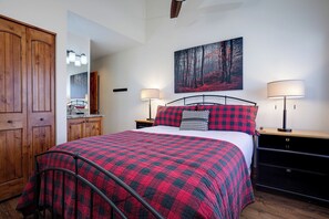 A bedroom with a bed, two bedside lamps, a painting on the wall, and a wooden wardrobe. - TR1211 | Phenomenal Mtn Getaway | Close to Skiing | Hot Tubs | A/C (Steamboat Springs)