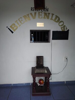 A reception area with a welcome sign, a small window, and a plaque.