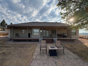 Una casa moderna amb un porxo cobert, mobiliari per a l'exterior i vistes al paisatge.