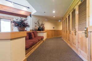 A hotel lobby with a reception desk, a seating area with red cushions, wooden lockers, and potted plants. - TR1304 | Perfect Mountain Getaway | Modern Décor | A/C | Hot Tubs (Steamboat Springs)