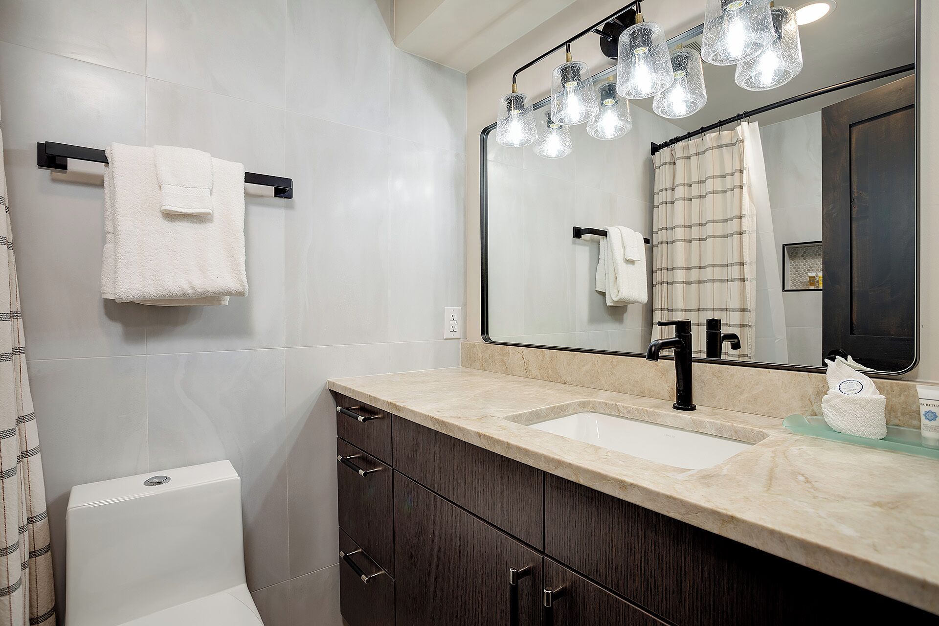 Un bagno moderno con un grande specchio, due lavabi e un water.
