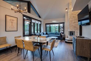 A modern interior with a dining area, a sofa, and a kitchen. - TR1310 | Mountain Condo with Beautiful Views | A/C | 10 Hot Tubs (Steamboat Springs)