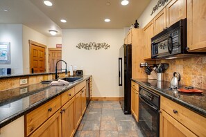 A kitchen with wooden cabinets, a stainless steel refrigerator, a microwave, and a dishwasher. - CL3103 | Newly Modern| Close to Skiing | A/C | 10 Hot Tubs (Steamboat Springs)