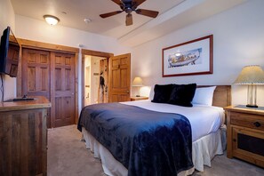 A bedroom with a bed, wooden wardrobe, ceiling fan, and a framed picture on the wall. - TL2209 | Close to Slopes | A/C | 10 Hot Tubs | 4 Pools (Steamboat Springs)