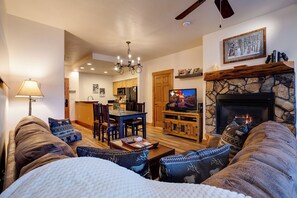 A cozy living room with a fireplace, a dining area, and a kitchen in the background. - TL2209 | Close to Slopes | A/C | 10 Hot Tubs | 4 Pools (Steamboat Springs)