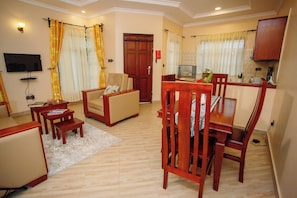 A living room with a TV, wooden furniture, and a door.