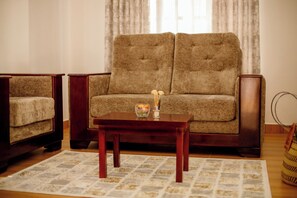 A living room with a sofa, a chair, a coffee table, and a rug.