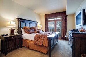 A bedroom with a large bed, two bedside tables, a dresser, a television, and a window with curtains. - EL5302 | Great Mountain Escape | Top Floor with Vaulted Ceiling | Air Chilling (Steamboat Springs)