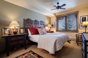 A bedroom with a bed, nightstands, a ceiling fan, and a window with blinds. - CL3305 | Top Floor | Vaulted Ceilings | 10 Hot Tubs | Winter Shuttle | 4 Pools (Steamboat Springs)